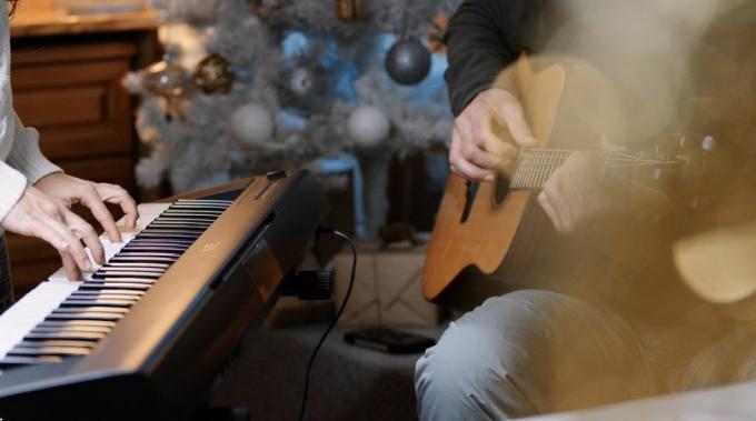 pareja tocando música juntos en vísperas de navidad en casa