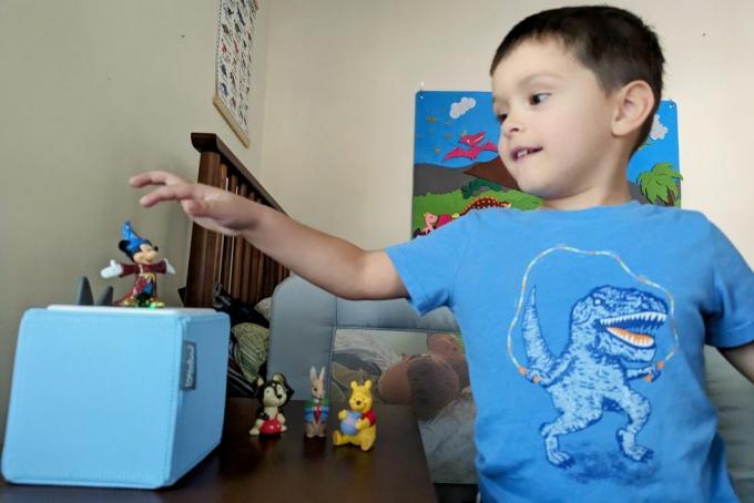 un niño jugando con un toniebox azul en una habitación infantil con los personajes de tonie mickey mouse, winne the pooh, cachorro y peter conejo