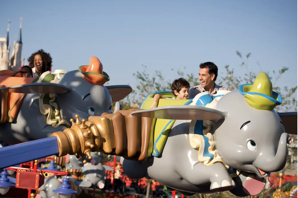 pasajeros montando a dumbo, el elefante volador, en el parque del reino mágico de walt disney world